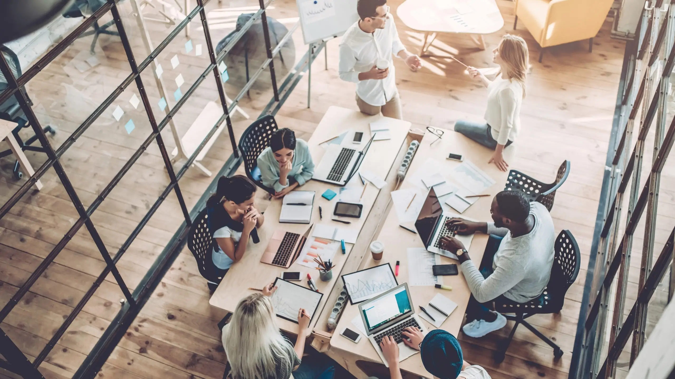 Equipo colaborando en una oficina moderna durante una sesión de trabajo